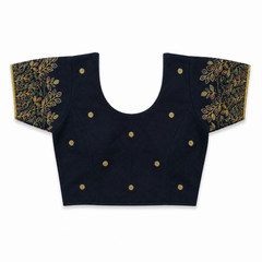 A dark navy blue or black short-sleeved stretchable readymade saree blouse with hand-embroidered golden leaf patterns on the sleeves and small gold floral motifs across the front, laid flat against a solid white background. Available in the UK at theindianshelf.co.uk.