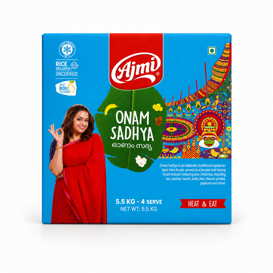 5.5kg square blue box of Ajmi Onam Sadhya centered on a white background, featuring a woman in a red saree next to a green banana leaf design and colorful Kathakali artwork. This product is available in the UK at theindianshelf.co.uk.