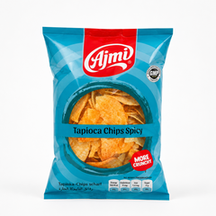 A professional studio shot of a stand-up pillow pouch of Ajmi Tapioca Chips Spicy The packaging features a vibrant, light cerulean blue background adorned with subtle, deep blue concentric circular patterns. A bold red vertical band drops down from the center top, highlighting the prominent white script "Ajmi" brand logo. To the right of the logo sits a circular silver "GOOD MANUFACTURING PRACTICE - GMP CERTIFIED" stamp.