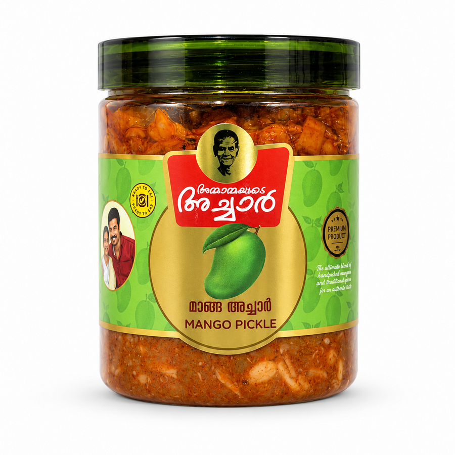 A professional studio shot of a transparent glass jar of Ammayammayude Achar Mango Pickle. The jar reveals a rich, red-orange spiced mango pickle base inside and is topped with a glossy, dark-green translucent ribbed lid. The central label features a bright lime-green background patterned with subtle mango doodles, centered around a large gold circle showcasing a fresh green mango with a leaf. Above the circle, This product is available in the UK at theindianshelf.co.uk.