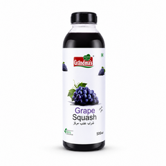 A professional studio product shot of a 500ml bottle of Grandma's Grape Squash isolated against a pure white background in image_918284.png. The transparent bottle shows a deep purple liquid inside and features a clean white label decorated with graphic illustrations of fresh purple grape clusters alongside the red and green brand logo.
