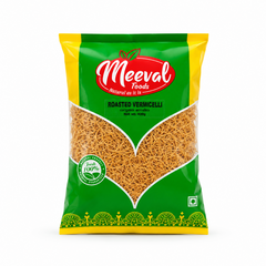 A professional studio product shot of a 400g retail pillow pouch of Meeval Foods Roasted Vermicelli isolated against a pure white background in image_7ccde1.jpg. The vibrant green and yellow packaging features a large, leaf-shaped clear window showcasing the golden-brown, fine strands of roasted vermicelli inside below the prominent red and white Meeval Foods logo. This product is available in the UK at theindianshelf.co.uk.