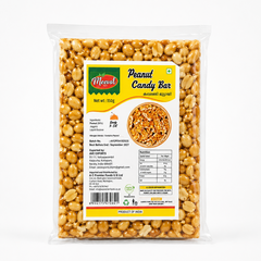 A professional studio shot showcasing a portioned block of Meeval Peanut Candy Bar inside a transparent flowwrap film package Through the clean plastic wrapper, rows of goldenbrown, whole roasted peanuts are completely visible held firmly together by a glossy translucent amber jaggery coating. The front label features a bright yellow background with a vertical dark green panel on the left side. The red oval "Meeval Foods" logo sits at the top left. This product is available in the UK at theindianshelf.co.uk