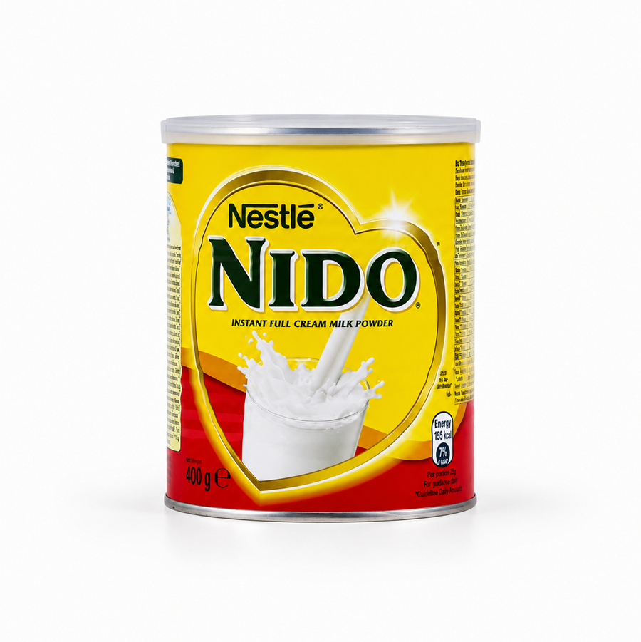 A 400g tin of Nestle Nido Instant Full Cream Milk Powder isolated on a white background, featuring a bright yellow and red label with a prominent heart-shaped border framing a graphic of a splashing glass of milk. This product is available in the UK at theindianshelf.co.uk.