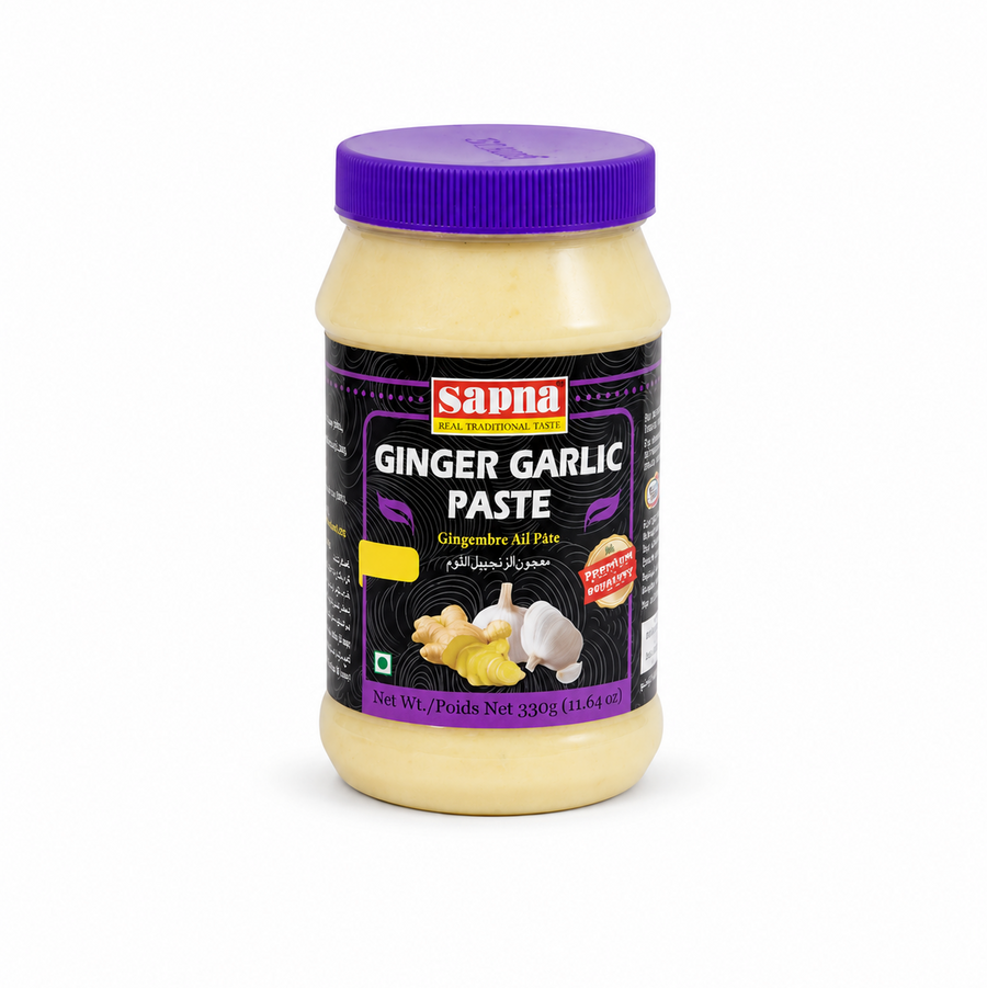 A 330g clear plastic jar of Sapna Ginger Garlic Paste centered on a solid white background, featuring a vibrant purple ribbed screw cap and a black label showcasing graphics of fresh ginger root, garlic bulbs, and the red Sapna brand logo.