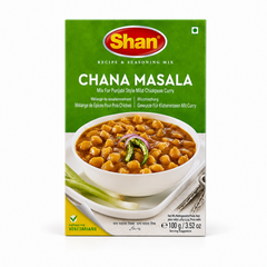A 100g box of Shan Chana Masala Recipe & Seasoning Mix centered on a solid white background, featuring a bright green top section with the Shan logo and a serving suggestion showing a white bowl filled with chickpeas in gravy garnished with sliced onion rings and green chilies. This product is available in the UK at theindianshelf.co.uk.