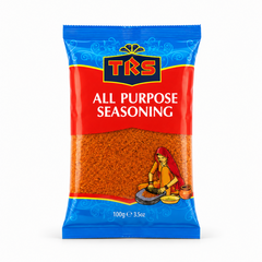 A 100g pouch of TRS All Purpose Seasoning centered on a solid white background, featuring a vibrant blue and red packaging design with the TRS logo and a clear window showing the orange-brown grounded spice mix next to an illustration of a woman using a grinding stone. This product is available in the UK at theindianshelf.co.uk.