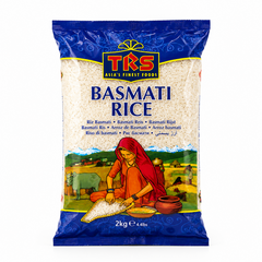 A 2kg bag of TRS Basmati Rice centered on a white background, featuring a vibrant blue frame around a clear window showing raw white rice grains above a colorful illustration of a woman sifting rice in a rural landscape. This product is available in the UK at theindianshelf.co.uk.