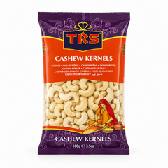 A 100g pouch of TRS Cashew Kernels centered on a solid white background, featuring a purple and orange ornate packaging design with the TRS logo and a clear window revealing the whole raw cashew nuts alongside an illustration of a traditional Indian woman. This product is available in the UK at theindianshelf.co.uk.