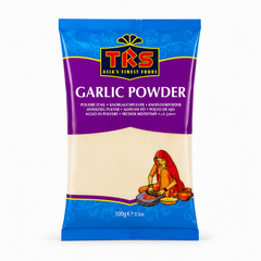 A 100g pouch of TRS Garlic Powder centered on a solid white background, featuring a vibrant purple and blue packaging design with the TRS logo and a clear window showing off-white finely ground garlic powder next to an illustration of a traditional Indian woman using a grinding stone. This product is available in the UK at theindianshelf.co.uk.