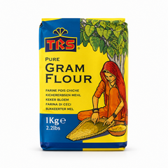 A 1kg block bag of TRS Pure Gram Flour centered on a solid white background, featuring a bright yellow and blue package with the brand logo and an illustration of a woman in traditional attire winnowing grains under a tree. This product is available in the UK at theindianshelf.co.uk