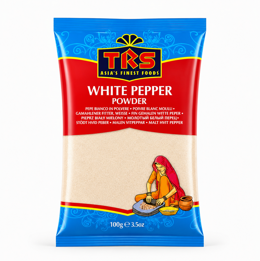 A 100g pouch of TRS White Pepper Powder centered on a solid white background, featuring a vibrant red and blue packaging design with the TRS logo and a clear window displaying off-white finely ground pepper next to an illustration of a traditional Indian woman using a grinding stone. This product is available in the UK at theindianshelf.co.uk.