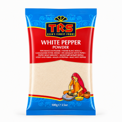 A 100g pouch of TRS White Pepper Powder centered on a solid white background, featuring a vibrant red and blue packaging design with the TRS logo and a clear window displaying off-white finely ground pepper next to an illustration of a traditional Indian woman using a grinding stone. This product is available in the UK at theindianshelf.co.uk.