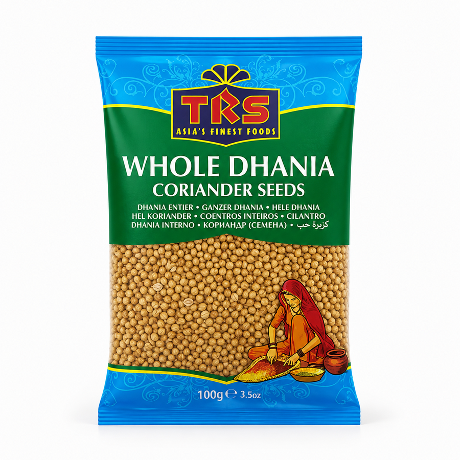 A 100g pouch of TRS Whole Dhania Coriander Seeds centered on a white background, featuring a vibrant blue and green label with the brand logo and an illustration of a woman traditional-sorting spices, displaying the golden whole seeds through a transparent lower window. This product is available in the UK at theindianshelf.co.uk.