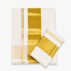 A neatly folded off-white Kerala tissue cotton single set mundu with matching neryathum placed diagonally on top against a solid white background, featuring an all-over golden check pattern and a wide metallic gold zari (kasavu) border. Available in the UK at theindianshelf.co.uk.