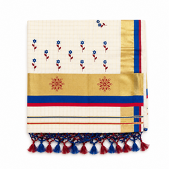 A square-folded off-white tissue saree centered on a solid white background, showing a fine grid pattern with hand-painted blue and red floral motifs, a wide golden kasavu border with two red hand-painted floral emblems, royal blue and red accent stripes, and dual-tone blue and red knotted fringe tassels along the bottom.