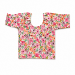 A colorful floral print readymade stretchable saree blouse displayed flat on a white background, featuring short sleeves, a scoop neck, and a vibrant pattern of pink, orange, and purple flowers. Available in the UK at theindianshelf.co.uk.