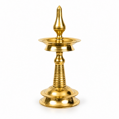 A 10-inch traditional brass Kerala kuthu vilakku standing oil lamp with a round base and polished golden finish, centered on a solid white background. Available in the UK at theindianshelf.co.uk.