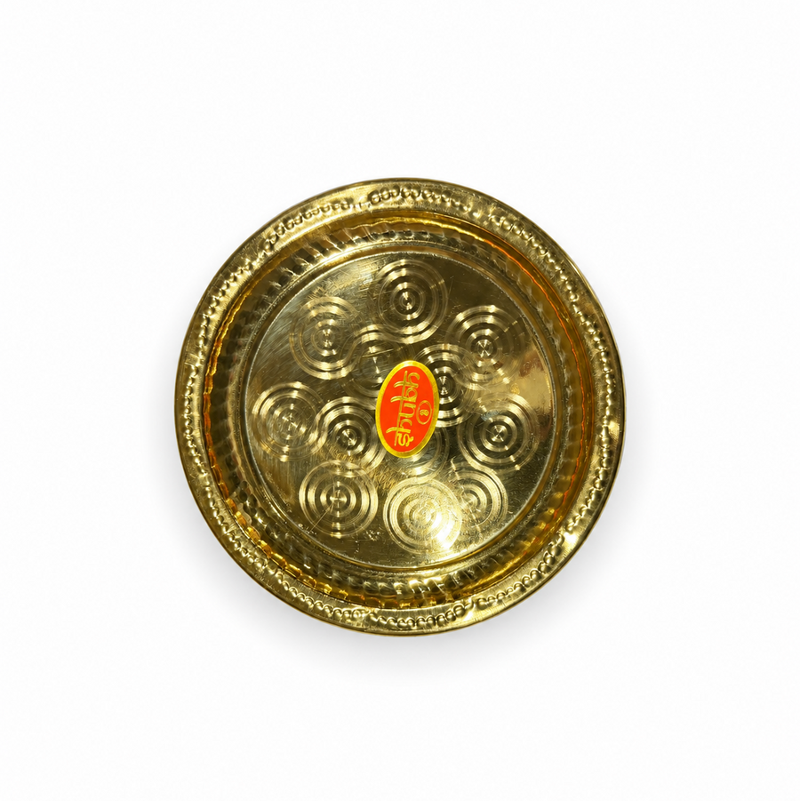 An 8-inch Shubh brass plate featuring concentric circular patterns and a decorative rim, centered on a solid white background. Available in the UK at theindianshelf.co.uk.