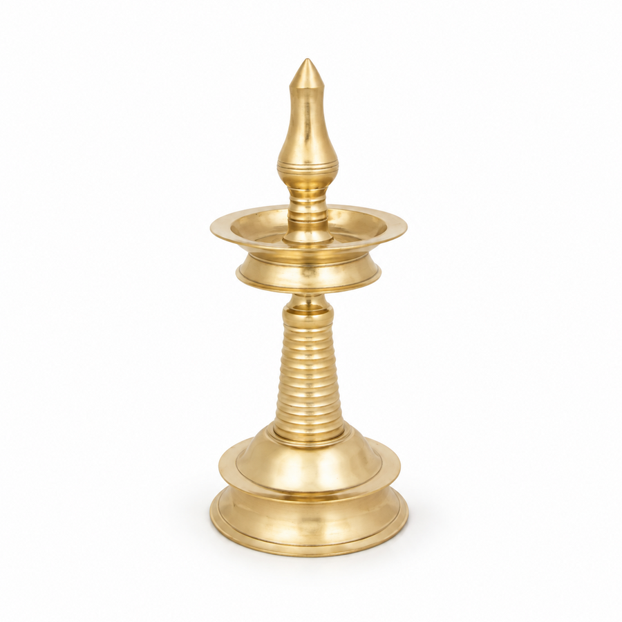 An 8-inch traditional brass Kerala kuthu vilakku standing oil lamp with a round base and polished golden finish, centered on a solid white background. Available in the UK at theindianshelf.co.uk.