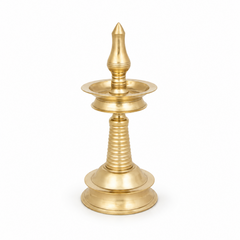 An 8-inch traditional brass Kerala kuthu vilakku standing oil lamp with a round base and polished golden finish, centered on a solid white background. Available in the UK at theindianshelf.co.uk.