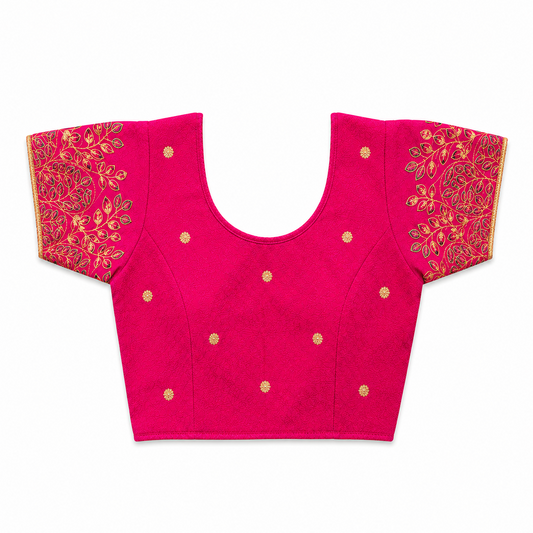 A bright magenta pink short-sleeved stretchable readymade saree blouse with hand-embroidered golden leaf patterns on the sleeves and small gold floral motifs across the front, laid flat against a solid white background. Available in the UK at theindianshelf.co.uk.