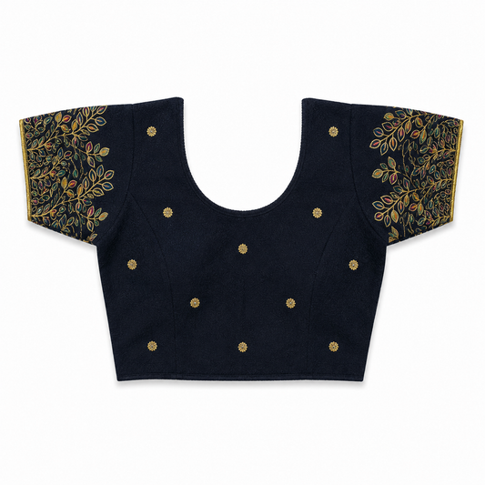 A dark navy blue or black short-sleeved stretchable readymade saree blouse with hand-embroidered golden leaf patterns on the sleeves and small gold floral motifs across the front, laid flat against a solid white background. Available in the UK at theindianshelf.co.uk.