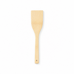 A natural light wood flat cooking spatula turner with a hanging hole at the handle tip, displayed vertically against a solid white background. Available in the UK at indianshelf.co.uk.