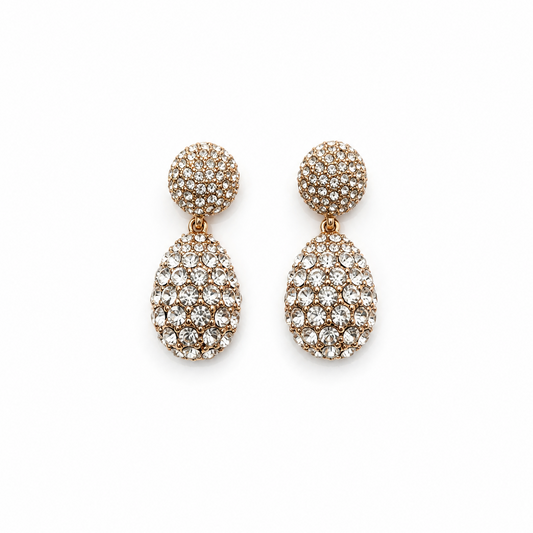 A pair of gold-tone two-tier drop earrings fully encrusted with clear pavé crystals against a solid white background. Available in the UK at indianshelf.co.uk.