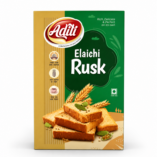 A professional studio shot of a box of Aditi Elaichi Rusk. The packaging features a vertical split design with a textured light-gold panel on the left and a vibrant deep-green section on the right. The distinctive red and white oval "Aditi" logo sits at the top left above three round icons highlighting "Made from best sources," and "Best tea time snack." The product name "Elaichi Rusk" is printed in bold white text over a dark green shape.This product is available in the UK at theindianshelf.co.uk.