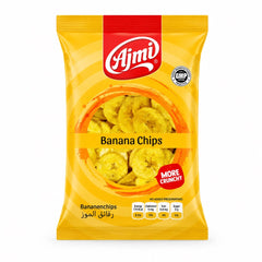 A professional studio shot of the Ajmi Banana Chips packaging as seen in image_e2610f.jpg. The bag is a vibrant yellow with concentric orange circles creating a sunburst effect. A central circular window shows the golden, round banana chips inside. The red "Ajmi" logo is at the top center, and a red "MORE CRUNCHY" seal is featured on the right.  badge and a nutritional table showing 170 kcal energy, 0 mg cholesterol, 0.8 mg iron, and 0 g sugar.This product is available in the UK at theindianshelf.co.uk.