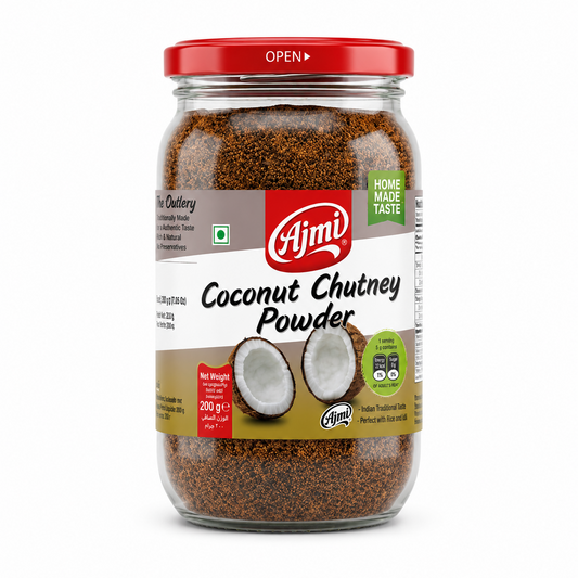 A professional studio shot of a 200g glass jar of Ajmi Coconut Chutney Powder. The jar is filled with a coarse, dark-brown roasted coconut and spice mixture. The label features a clean white and gold design with the red "Ajmi" logo at the top center. Below the branding, a graphic shows two halves of a fresh brown coconut. The label prominently displays a green "HOME MADE TASTE" seal and a green "Net Weight 200 g" banner. This product is available in the UK at theindianshelf.co.uk.