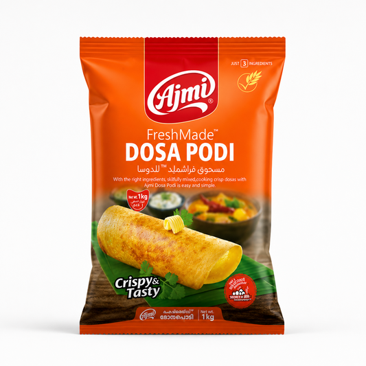 A studio product shot of a vertical 1 kg pillow pouch of Ajmi FreshMade Dosa Podi against a crisp white background. The packaging features a vibrant orange theme with a bold red vertical strip at the top center featuring the white "Ajmi" logo. Below the logo, the product title "FreshMade DOSA PODI" is written in large white lettering. This product is available in the UK at theindianshelf.co.uk.