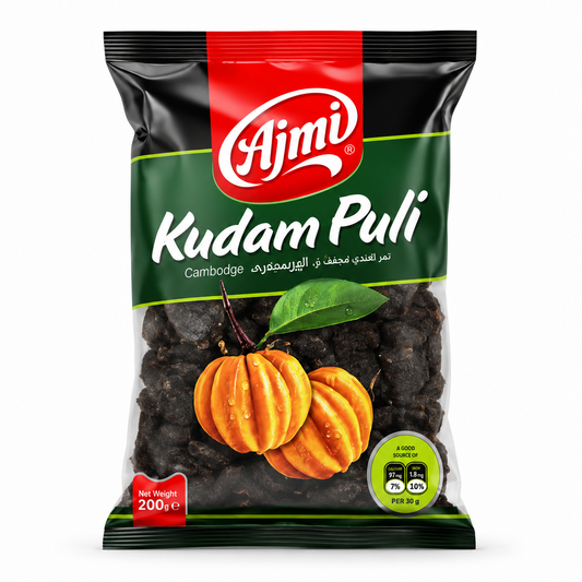 A professional studio shot of the Ajmi Kudam Puli packaging.The bag features a dark green and black design with a prominent red vertical stripe at the top containing the white "Ajmi" logo. Below the brand name, "Kudam Puli" is written in a large, white script. A transparent window in the lower half reveals the dark, dried tamarind pieces inside, overlaid with an illustration of two bright orange, fresh Cambodge fruits with a green leaf This product is available in the UK at theindianshelf.co.uk.