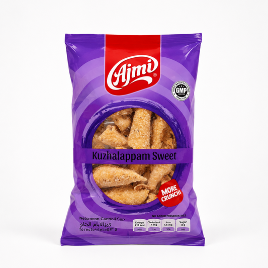 A professional studio shot of a stand-up pillow pouch of Ajmi Kuzhalappam Sweet The packaging features a vibrant purple background adorned with concentric circular patterns. A bold red vertical band drops down from the center top, highlighting the prominent white script "Ajmi" brand logo. To the right of the logo sits a circular silver "GMP CERTIFIED PRACTICE" stamp. This product is available in the UK at theindianshelf.co.uk.