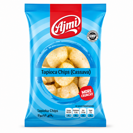 A professional studio shot of the Ajmi Tapioca Chips packaging as seen in image_e01a3d.jpg. The bag features a vibrant sky-blue design with concentric blue circles. The red "Ajmi" logo is centered at the top, and a red "MORE CRUNCHY" seal is featured on the lower right. The bottom of the bag includes a "GMP Certified" badge and a nutritional table showing 160 Kcal energy, 0 mg cholesterol, 1.4 mg iron, and 0 g sugar.This product is available in the UK at theindianshelf.co.uk.