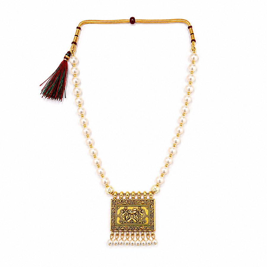 An antique gold-plated choker necklace featuring a single strand of white pearls and a rectangular pendant embossed with Lord Ganesha and finished with dangling mini pearls, displayed centered against a solid white background. Available in the UK at theindianshelf.co.uk.