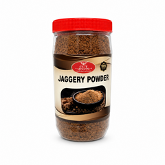 A transparent plastic jar with a red lid filled with rich brown CCT Jaggery Powder, featuring a cream and brown label with a graphic of a small bowl of jaggery, centered against a solid white background.