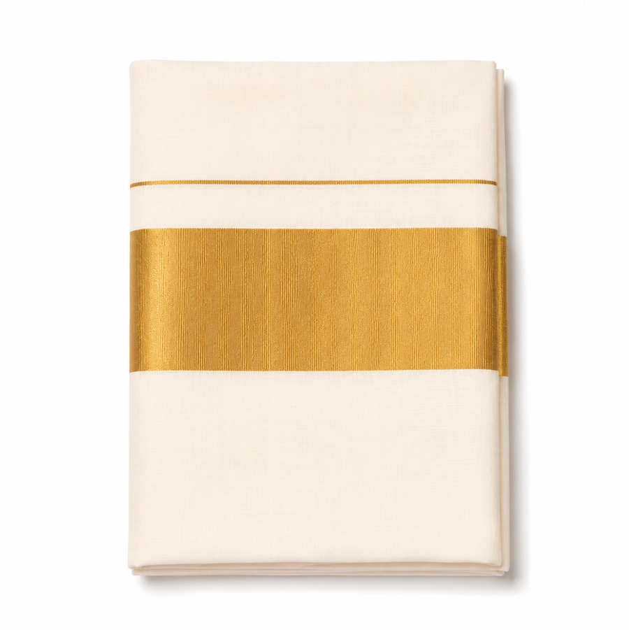 A neatly folded off-white classic Kerala cotton saree centered on a solid white background, featuring a wide metallic gold zari (kasavu) band and a fine parallel gold accent stripe. Product code VRT-S-2323JG, 6.25 meters. Available in the UK at theindianshelf.co.uk.
