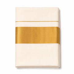 A neatly folded off-white classic Kerala cotton saree centered on a solid white background, featuring a wide metallic gold zari (kasavu) band and a fine parallel gold accent stripe. Product code VRT-S-2323JG, 6.25 meters. Available in the UK at theindianshelf.co.uk.