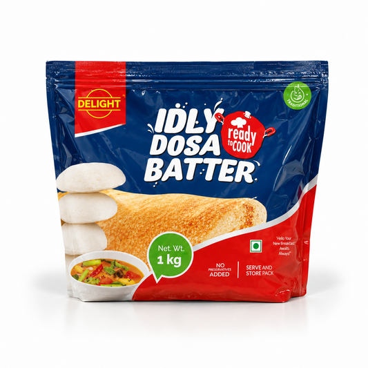 A 1 kg blue and red stand-up pouch of Delight Idly Dosa Batter featuring product branding and serving suggestions, centered on a solid white background. Available in the UK at theindianshelf.co.uk.