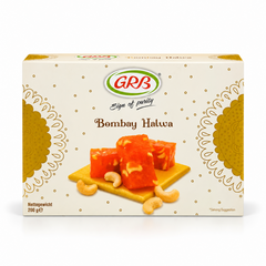 A 200g cream and gold retail box of GRB Bombay Halwa featuring brand logos and an arrangement of halwa pieces with cashew nuts, centered on a solid white background. Available in the UK at theindianshelf.co.uk.