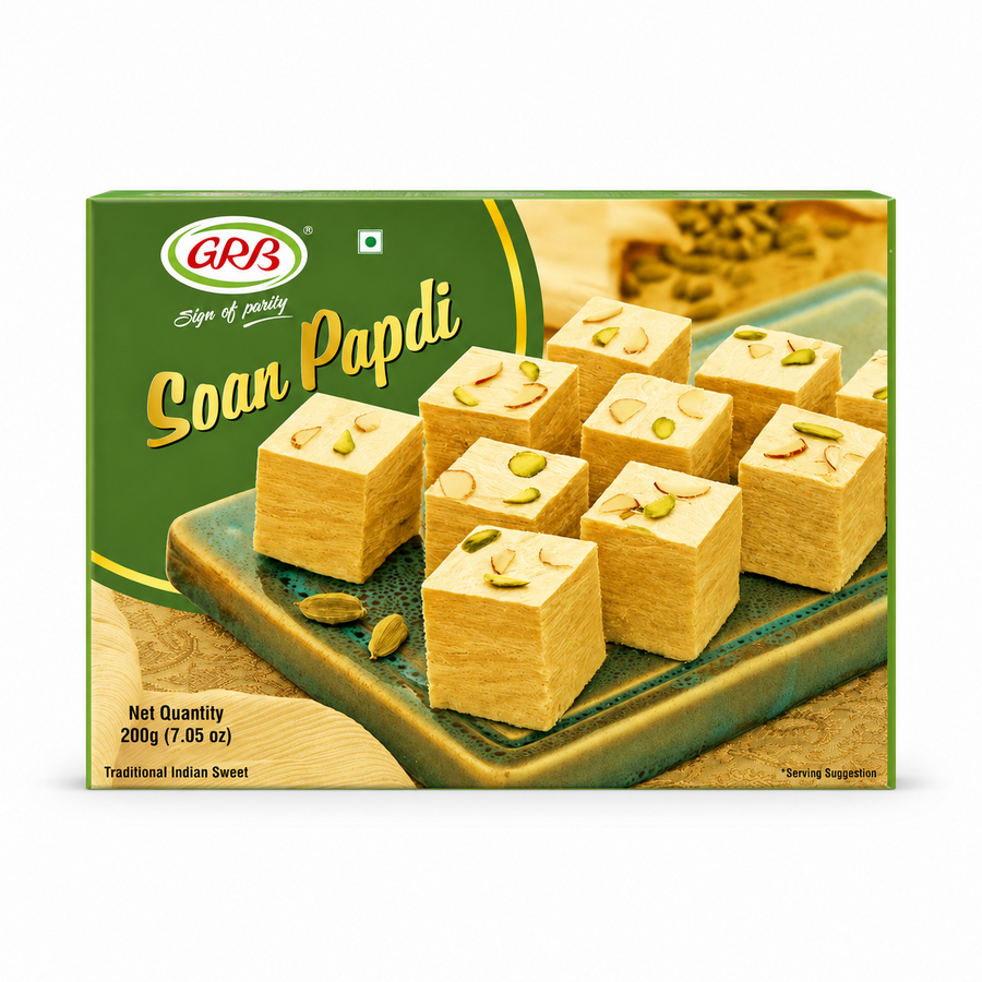 A professional studio product shot of a landscape-oriented rectangular green box for GRB Soan Papdi against a solid white background. The left third features a solid dark green background housing the oval green-and-red "GRB" logo, the script motto "Sign of purity," and the elegant golden title "Soan Papdi". The remaining portion displays a premium serving suggestion graphic showcasing nine perfectly square, This product is available in the UK at theindianshelf.co.uk.
