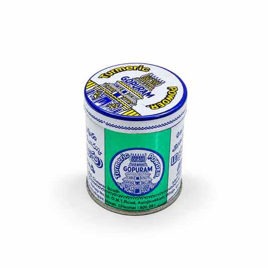 Around metal tin of Gopuram Turmeric Powder in blue and white branding, centered on a solid white background. Available in the UK at theindianshelf.co.uk.