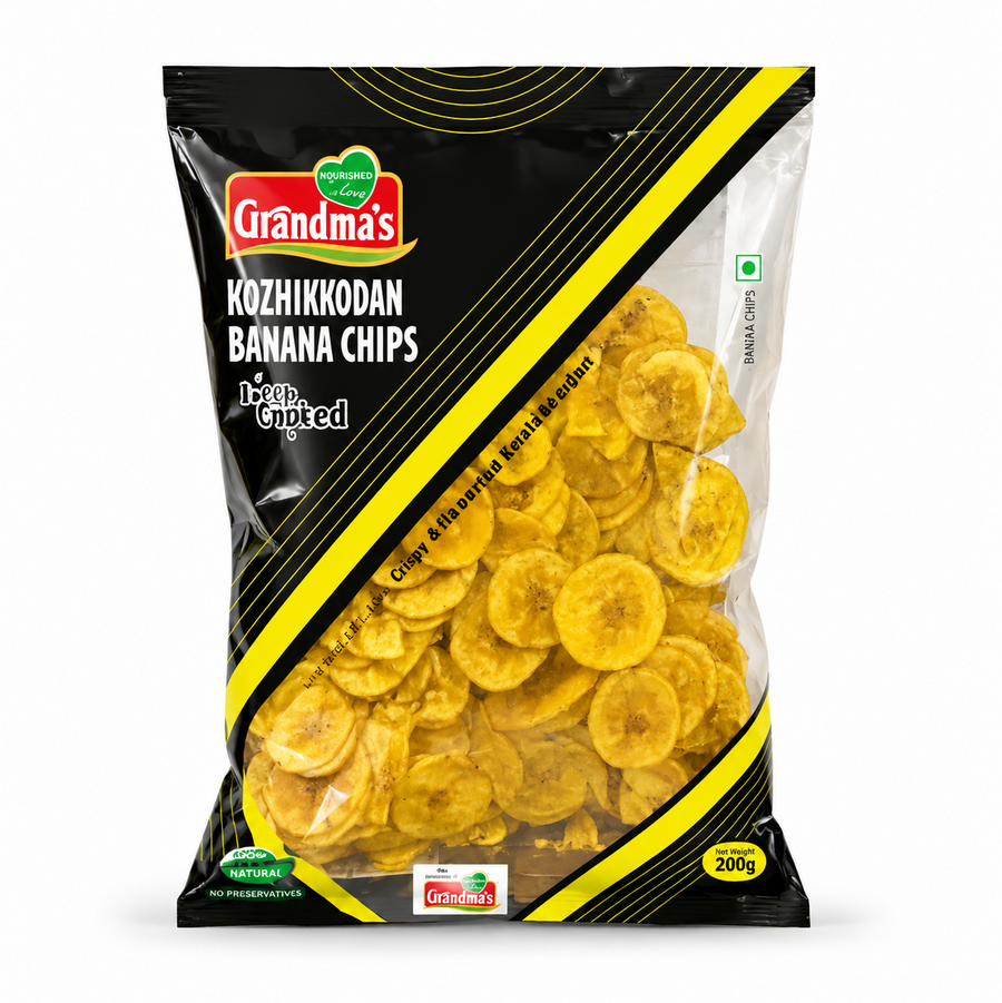 A professional studio shot of the Grandma's Kozhikkodan Banana Chips packaging.The bag features a sleek black design with bold yellow diagonal stripes and the red "Grandma's" logo at the top left. A large transparent window allows a clear view of the thin, golden-yellow round banana chips inside. The text "Kozhikkodan Banana Chips" and "Deep Crunched" are printed prominently.It indicates a net weight of 200g. This product is available in the UK at theindianshelf.co.uk.