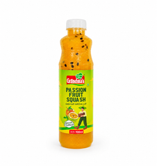 A professional studio product shot of a 700ml bottle of Grandma's Passion Fruit Squash isolated against a pure white background in image_7c593e.jpg. The transparent plastic bottle reveals a vibrant golden-yellow liquid containing real passion fruit seeds and features a bright green label decorated with illustrations of fresh passion fruit, a farmer carrying a fruit basket, and the red and green brand logo. This product is available in the UK at theindianshelf.co.uk.