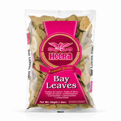 A 50g clear packet of Heera Bay Leaves centered on a solid white background, featuring a vibrant magenta label with the eagle logo and clear packaging displaying whole dried green bay leaves. This product is available in the UK at theindianshelf.co.uk.
