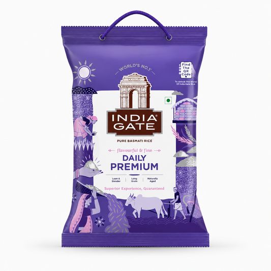 A professional studio product shot of a purple woven fabric bag of India Gate Daily Premium Basmati Rice featuring a top rope carrying handle against a solid white background. The front displays a central white shield block housing the brown historic India Gate monument illustration above the bold white brand text "INDIA GATE" on a dark brown banner. Below this, the title reads "DAILY PREMIUM" in dark purple lettering.This product is available in the UK at theindianshelf.co.uk.
