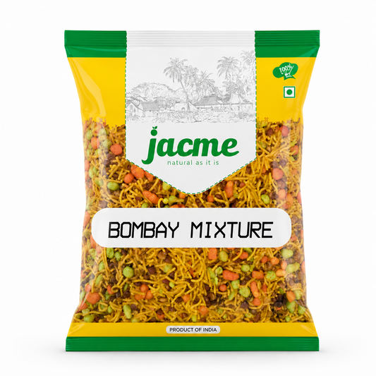 A professional studio shot of a bag of Jacme Bombay Mixture. The packaging features a vibrant yellow background with bright green accents at the top and bottom seals. A central white banner displays a subtle line-art illustration of a traditional village scene with palm trees, sitting directly above the green "jacme" logo with its tagline "natural as it is." This product is available in the UK at theindianshelf.co.uk.