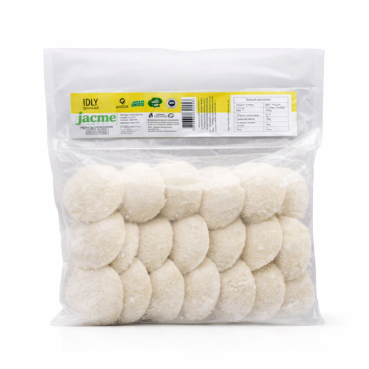 This is a clear, vacuum-sealed bulk pack of Jacme Frozen Idly. The package contains several pre-steamed, white, pillowy rice cakes that are frozen and ready to be reheated. A yellow and green header label provides the product name "IDLY" and includes the brand logo along with nutritional and manufacturing information.This authentic South Indian staple is available for purchase in the UK at theindianshelf.co.uk